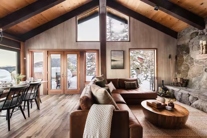 Ember Ridge living room with vaulted wood ceilings and stone wall